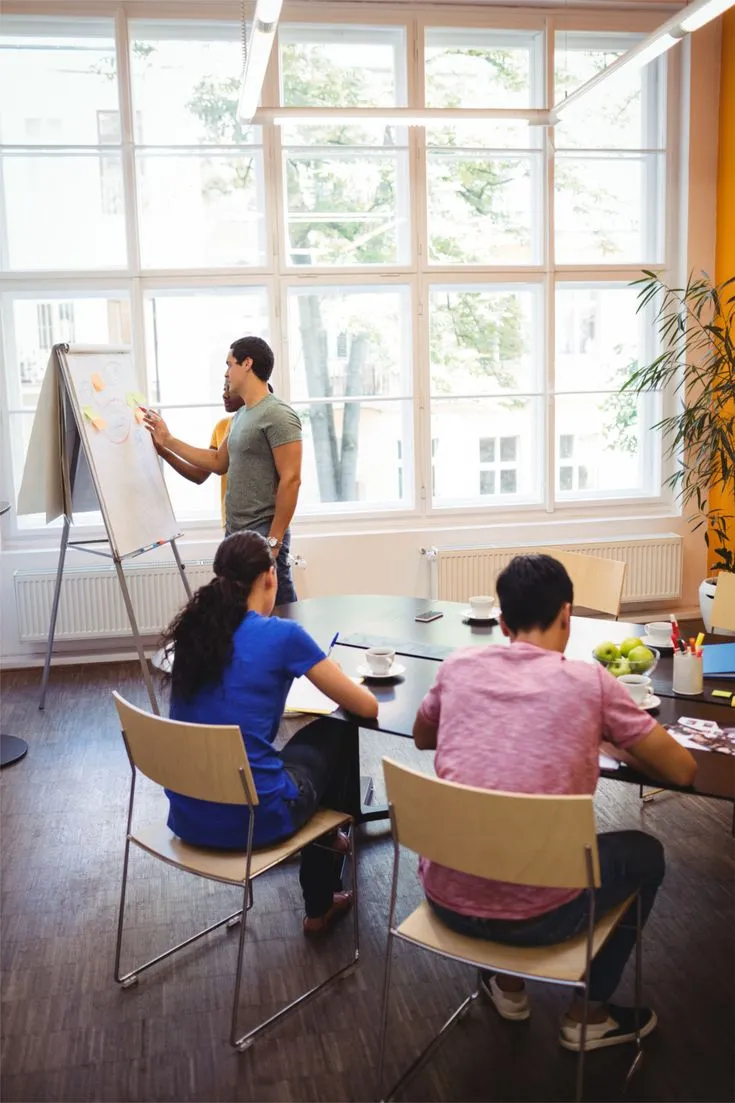 Team members reviewing activity schedule on whiteboard